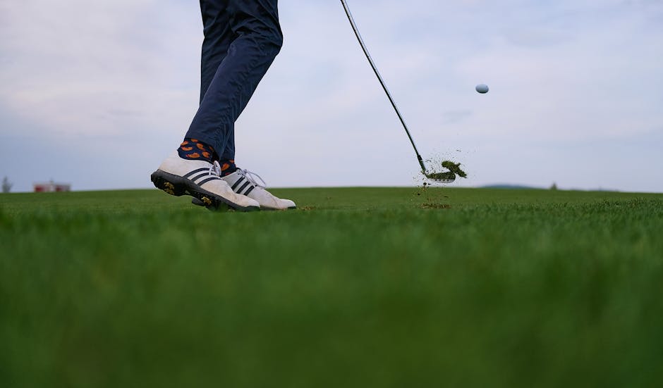 Capturing the dynamic power of a golf swing, a ball in mid-flight on a lush course.